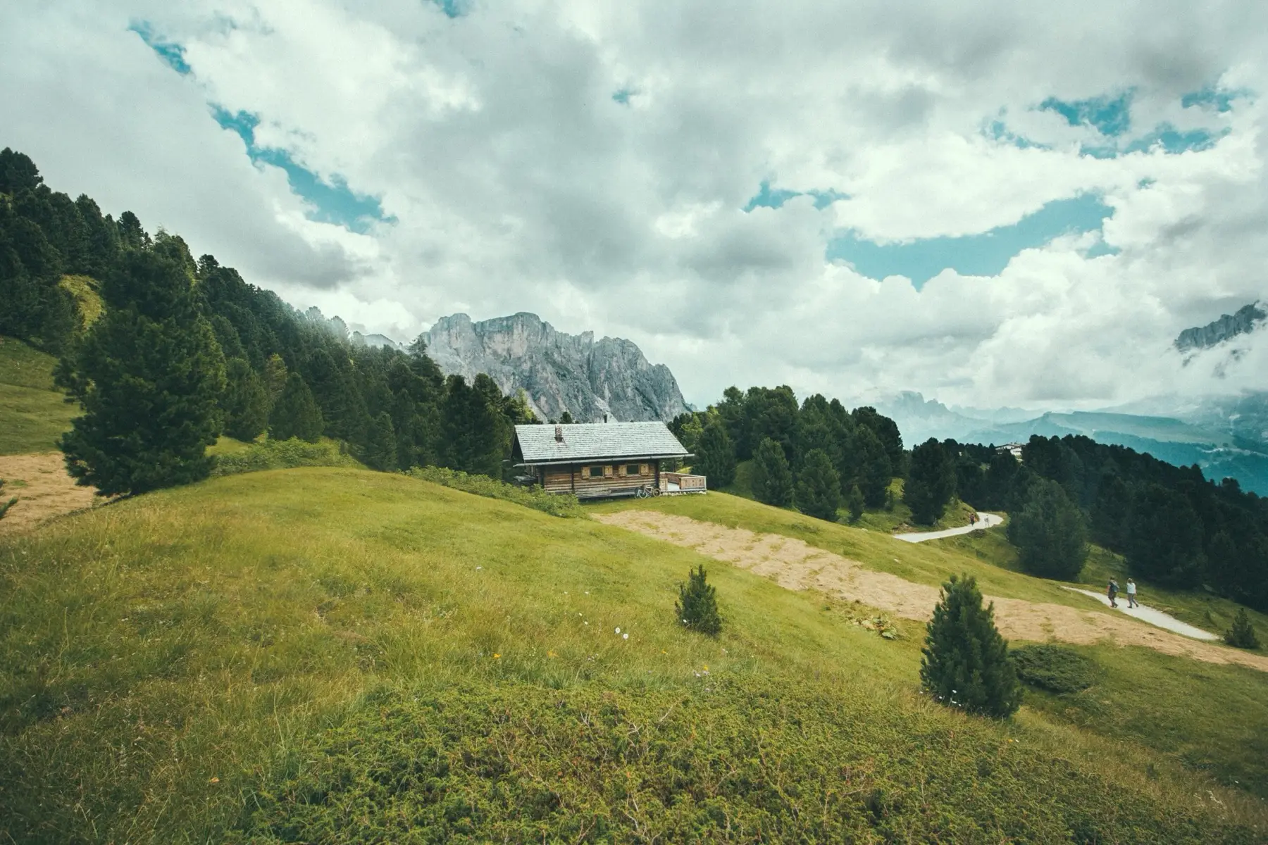 A wooden farmhouse on the meadows below the Seceda ridge