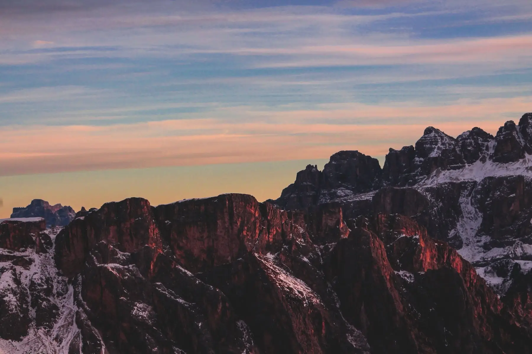 Seceda cliffs lit red under a violet dusk sky