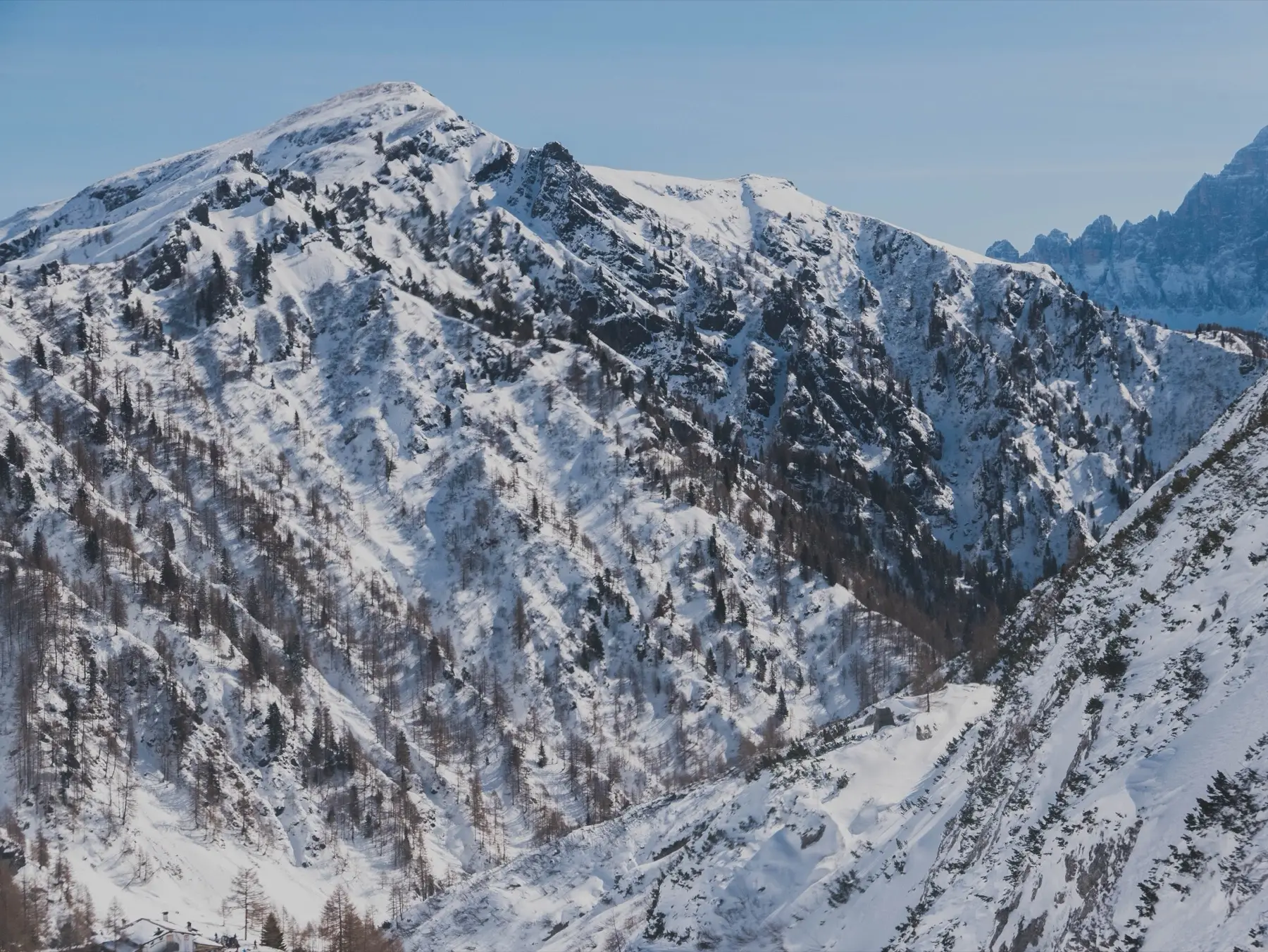 A snow-covered Dolomite summit under a clear sky